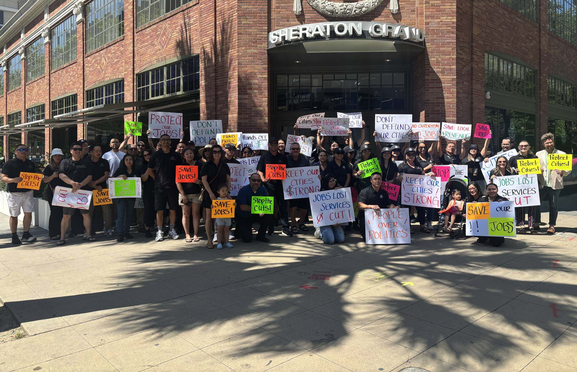 Cardroom employees and their families holding handmade signs in support of their jobs and the services their cities provide.